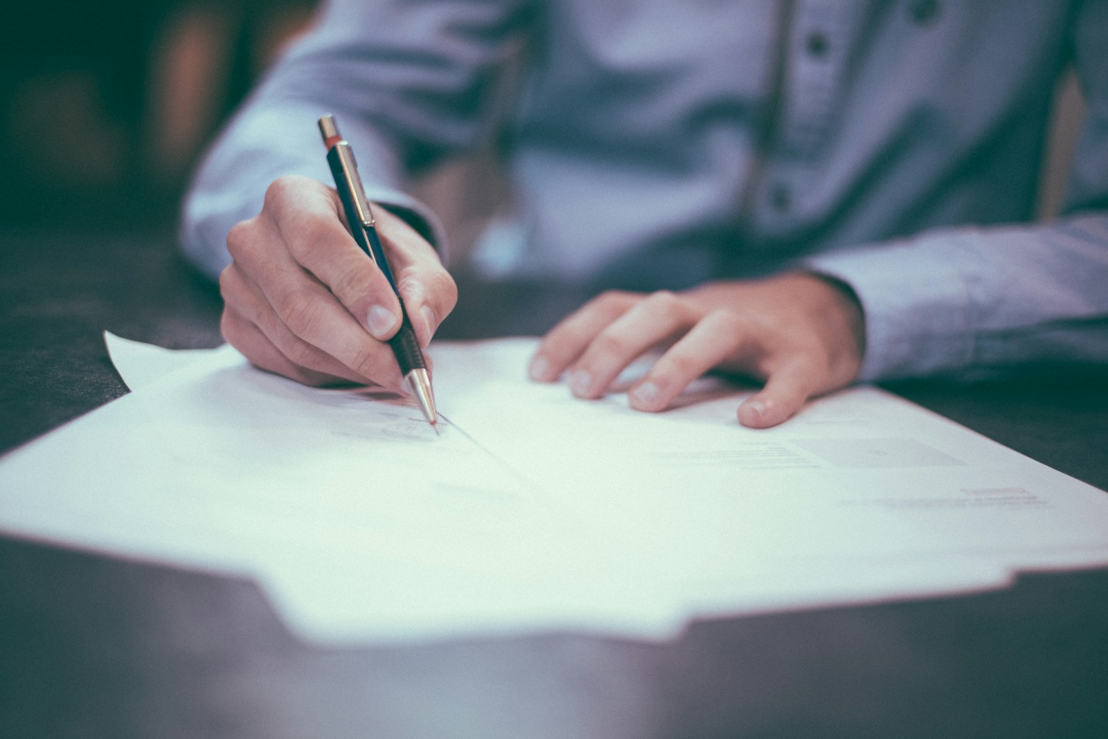 man writing on paper reviewing his homeowners policy