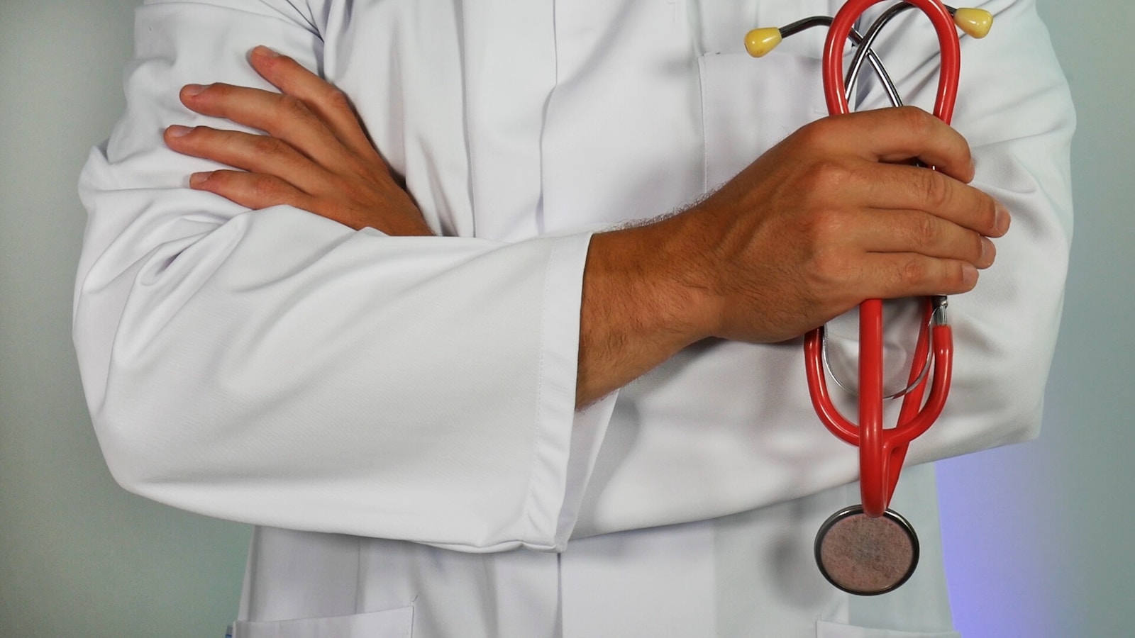 doctor holding red stethoscope attending to a patient with health insurance