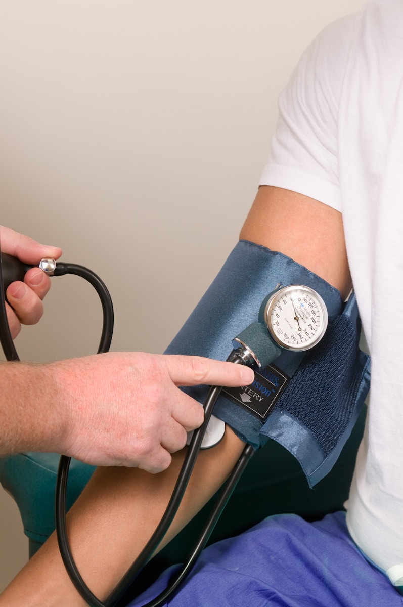 a doctor performing medical exams by checking the blood pressure of a patient